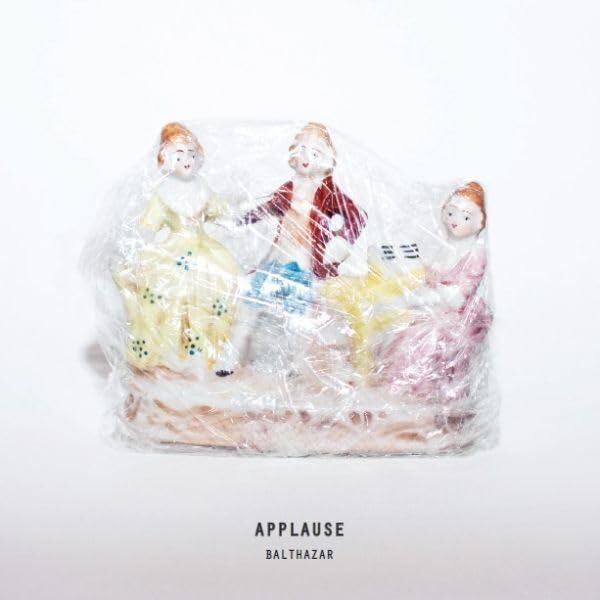 Vinyl record cover featuring three porcelain figurines and the word "APPLAUSE".