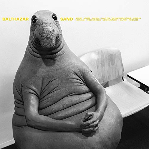 Black and white album cover featuring a seal-like creature in a chair.