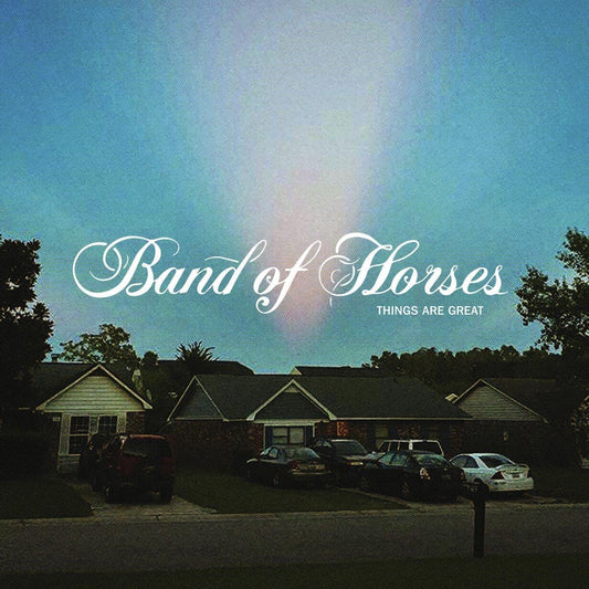 "Album cover with suburban houses and cars under a blue sky with white text."