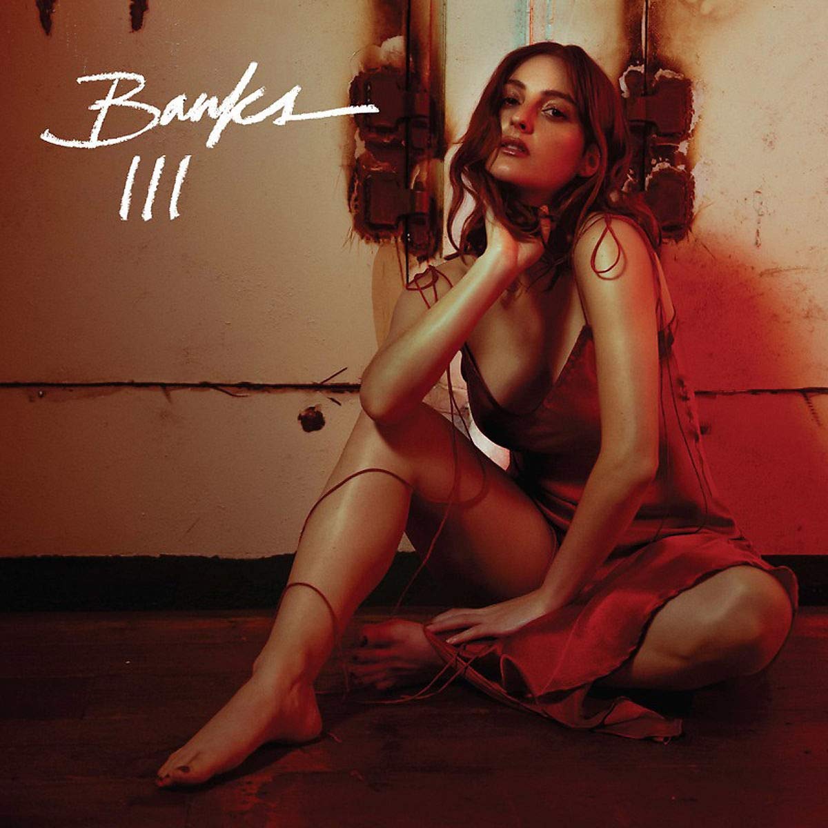Album cover featuring a woman in a red dress sitting on the floor, parental advisory logo.