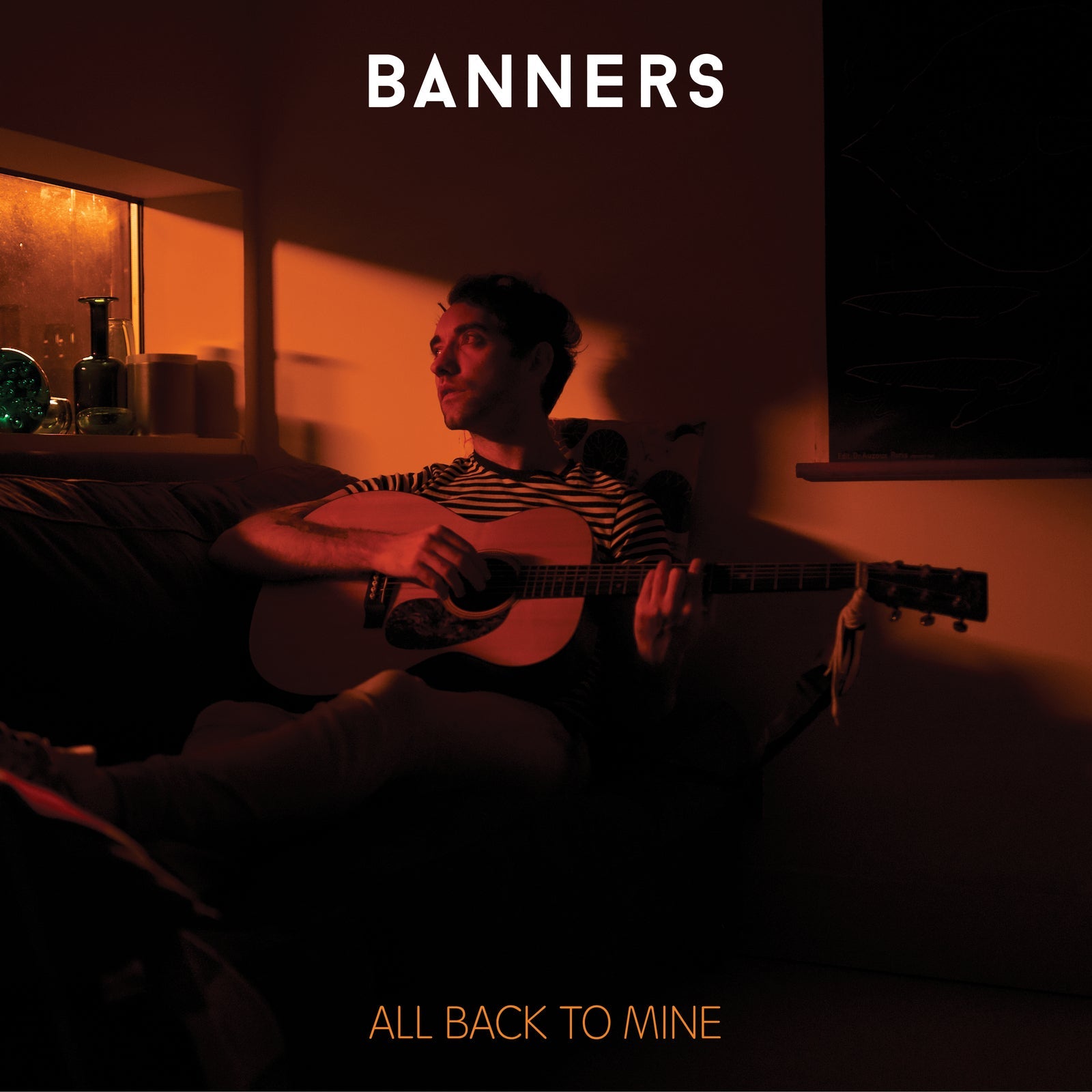 Man playing acoustic guitar, warm indoor lighting, album cover for Banners.