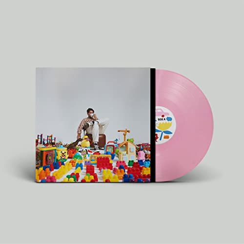 Vinyl record and album cover featuring a man amidst colorful toys.