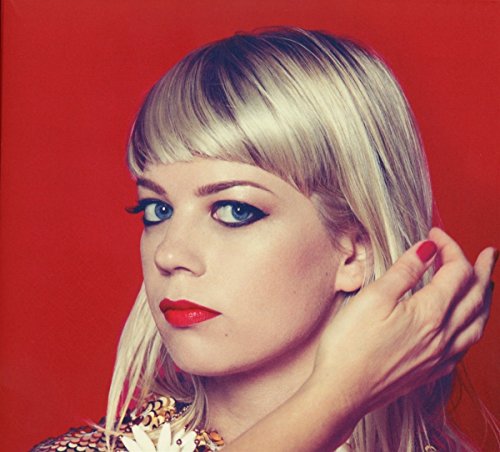 Close-up portrait of Basia Bulat with blonde hair and red lipstick.