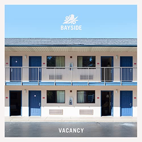 Two-story motel exterior with “Vacancy” sign, album cover art.