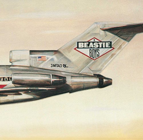 The tail section of a silver airplane featuring the Beastie Boys logo.