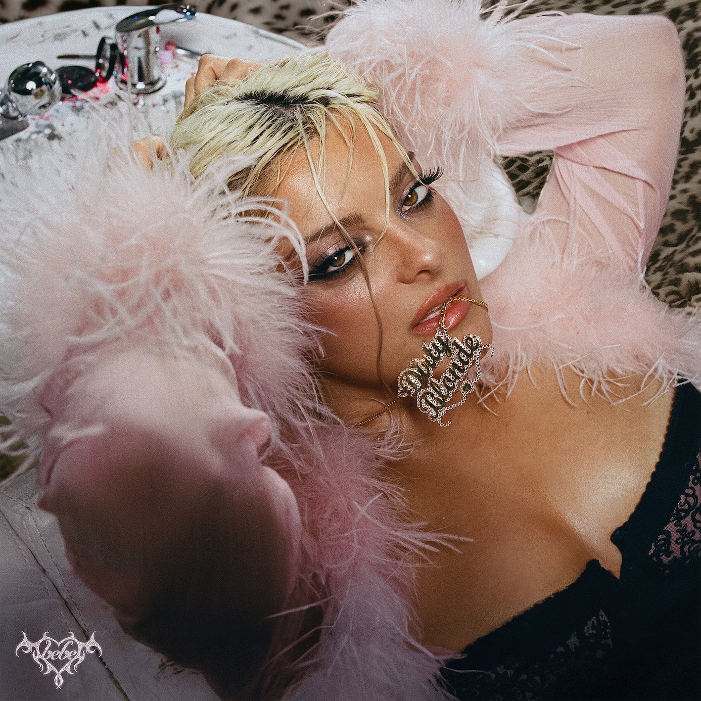 Bebe Rexha with blonde hair and a feather boa, looking at the viewer.