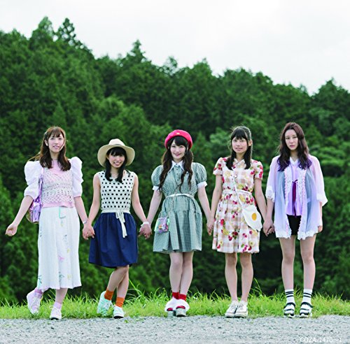Five young women in casual outfits stand in a line holding hands outdoors.
