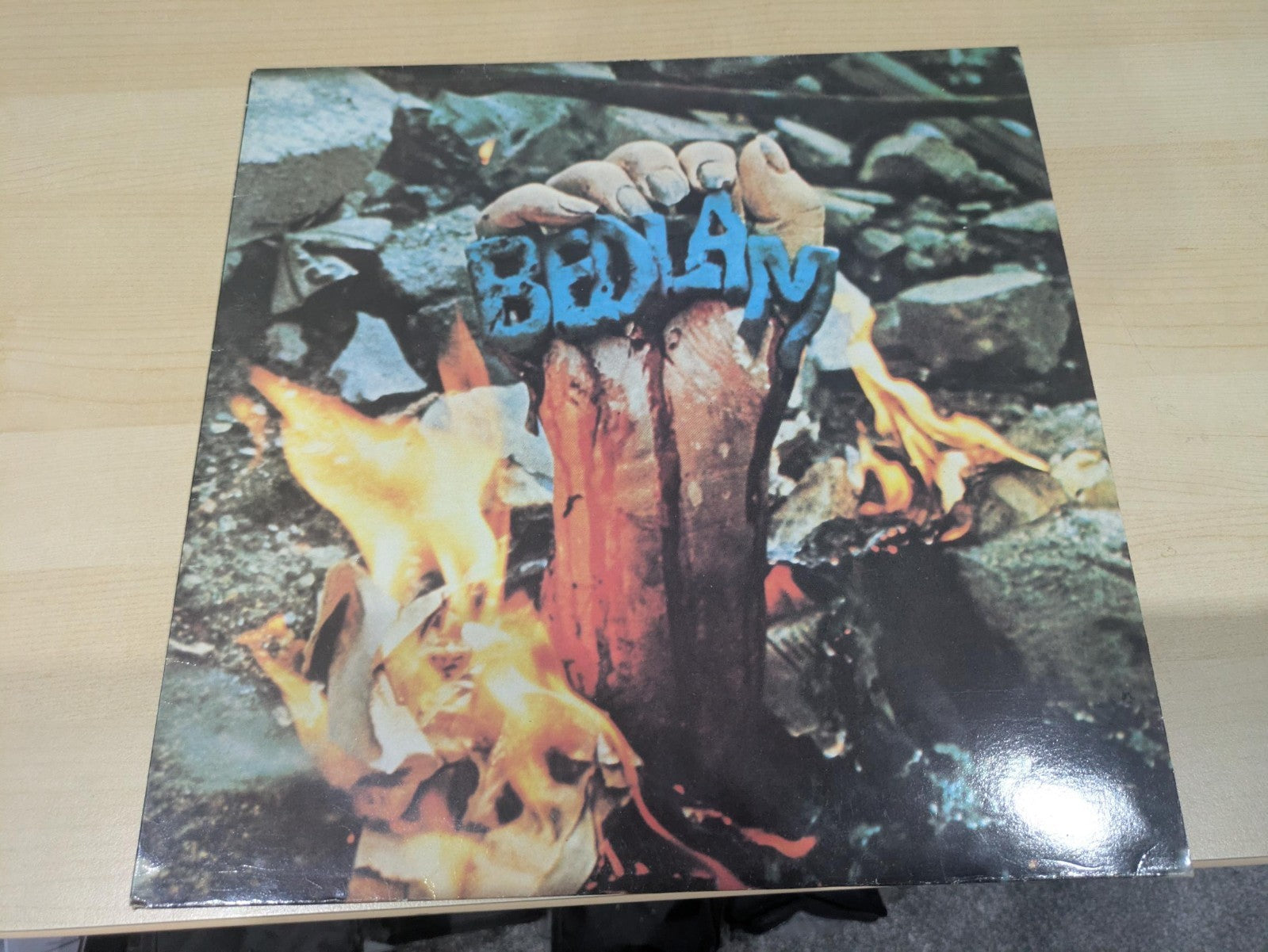Vinyl album cover showing a hand clutching blue Bedlam letters amidst fire and rubble.