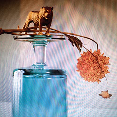 CD cover with a bronze tiger statue on a glass base and flower.