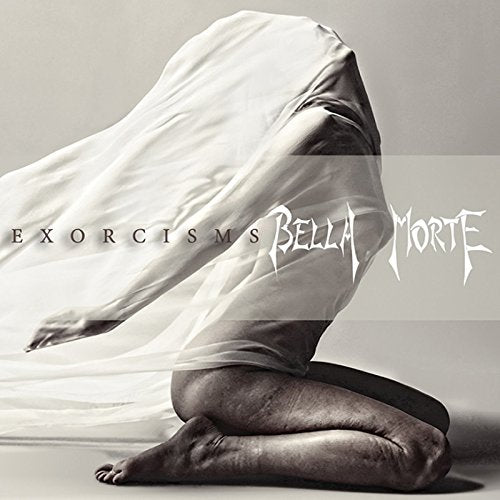 "Black and white image of a kneeling figure shrouded in white fabric."
