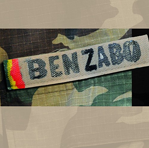A camouflage-patterned fabric with a white strip displaying "BENZABO" in black letters.