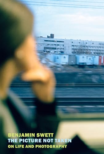 Book cover with blurred figure holding a camera, city view background.