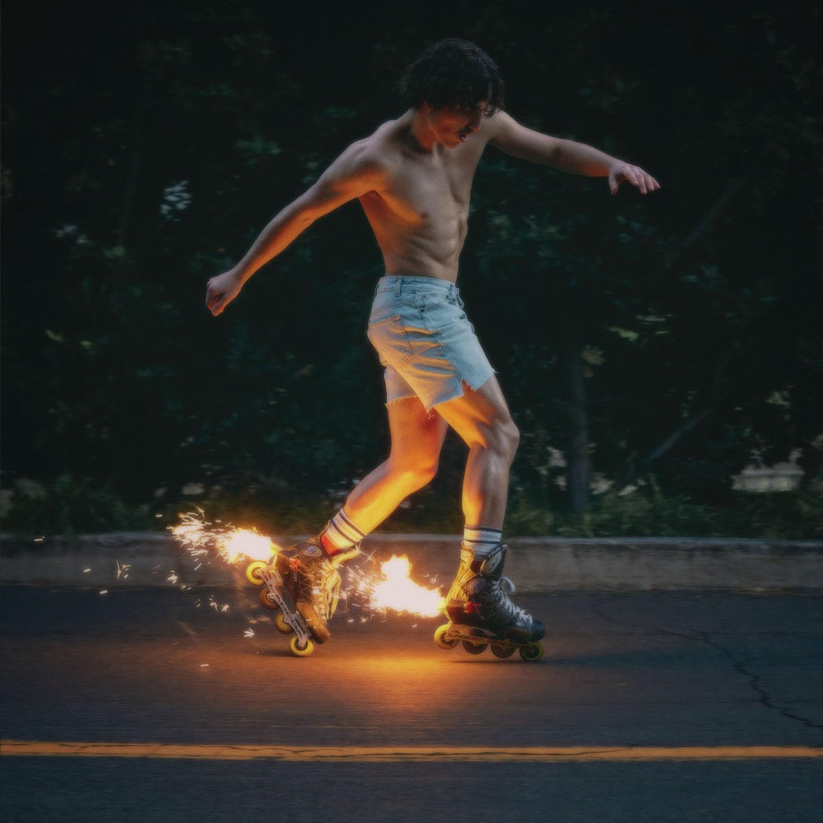 Man rollerblading at night with sparks flying from the wheels.