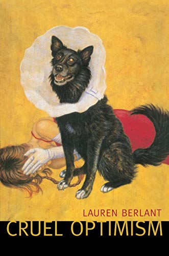 A black dog in a cone sits over a woman lying on a yellow background.