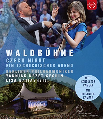 Conductor and violinist performing outdoors with orchestra and audience.