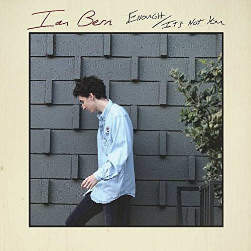 Vinyl album cover with a man walking beside a textured wall.