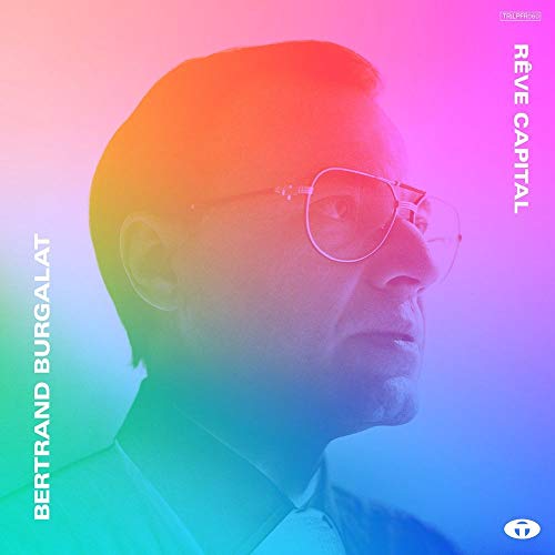 Profile portrait of Bertrand Burgalat wearing glasses against a vibrant, multicolored gradient background.