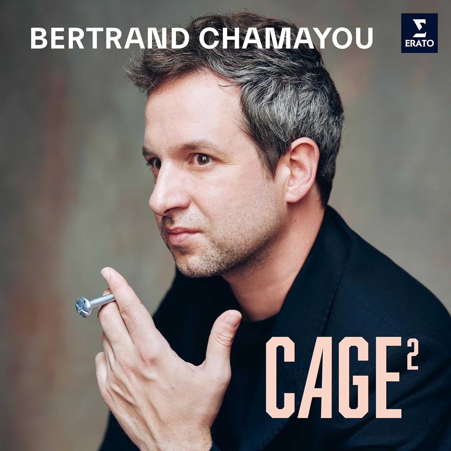 Portrait of Bertrand Chamayou, a pianist, holding a piano key.