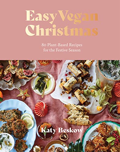 Cookbook cover with vegan Christmas food arranged on a pink surface.