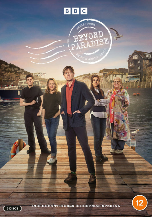 Five people standing on a dock with a town and water in the background.