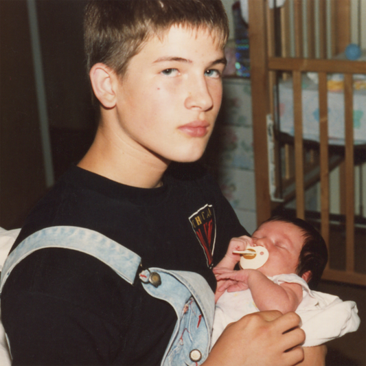 CD cover featuring a young man holding a newborn baby.
