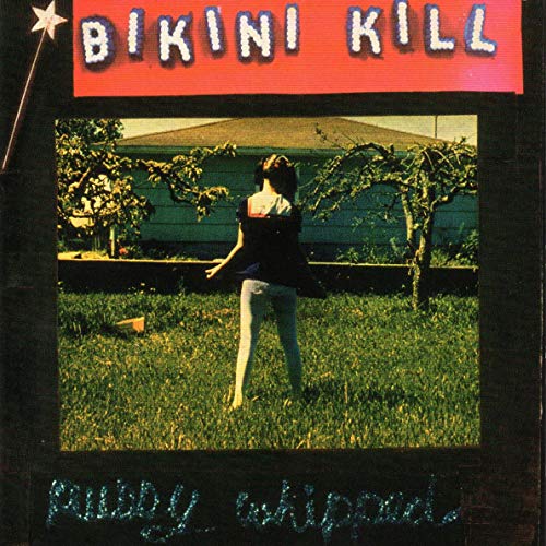 CD cover for Bikini Kill’s “Pussy Whipped,” showing a woman in a yard.