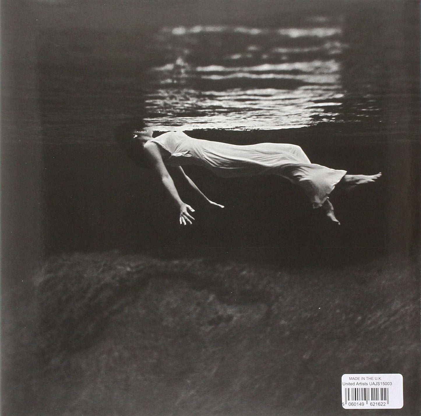 Black and white album cover depicting a person submerged in water.