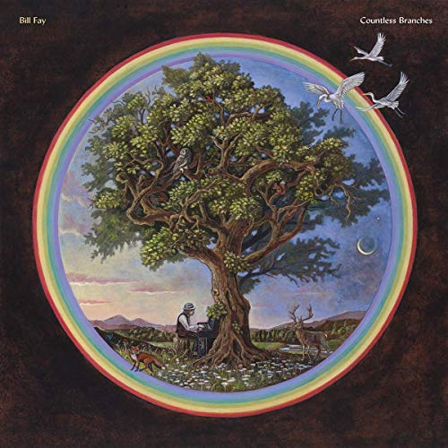 A man plays piano under a large tree inside a circular rainbow landscape.