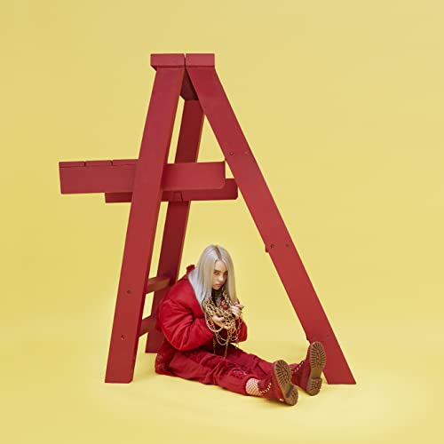 Billie Eilish with blonde hair wearing red clothing sits under a red wooden ladder.