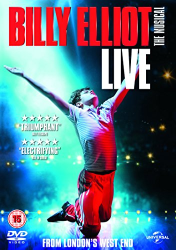 A young male dancer kneels on stage with arms outstretched under bright stage lights.