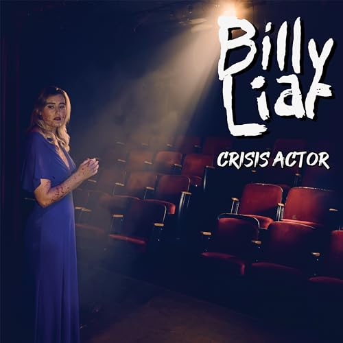 Woman in blue dress stands in empty, red-seated theater.