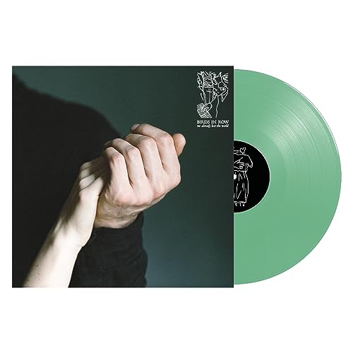 Green vinyl record with album cover showing hands and line art.