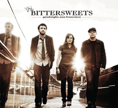 "CD cover featuring four band members walking on a bridge, sepia-toned image."