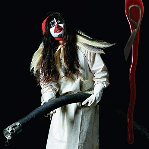 Björk in white robe with dramatic makeup, holding a dark hose.