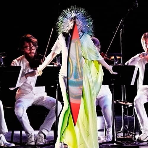 Björk performing with string orchestra, wearing a colorful, spiky headpiece.