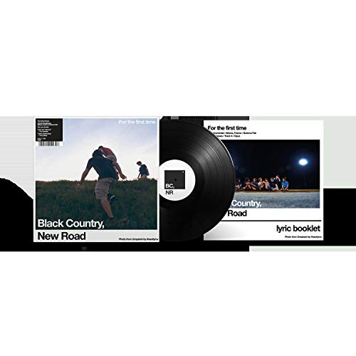 The image depicts a vinyl record and its cover art, featuring a photograph of three individuals on a grassy hill. The cover showcases the title "For the First Time" and the artist's name "Black Country, New Road." To create an alt text that is concise, descriptive, and accessible, we can focus on the key elements of the image. Here is a possible alt text: "Vinyl record with cover art featuring silhouetted figures on a hill." This alt text