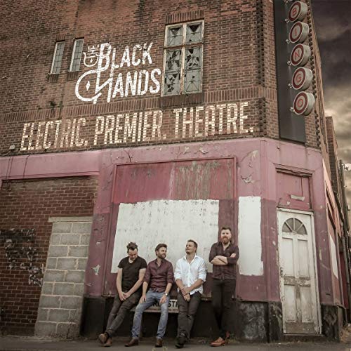 Four men stand in front of a brick building with a BINGO sign.