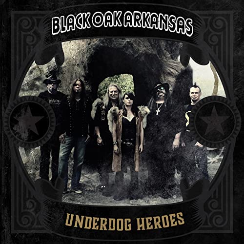 Black Oak Arkansas band members stand before a dark cave entrance.