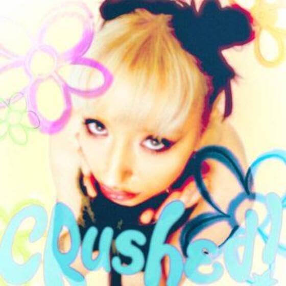 Close-up portrait of a young woman with blonde hair and the word "crushed".