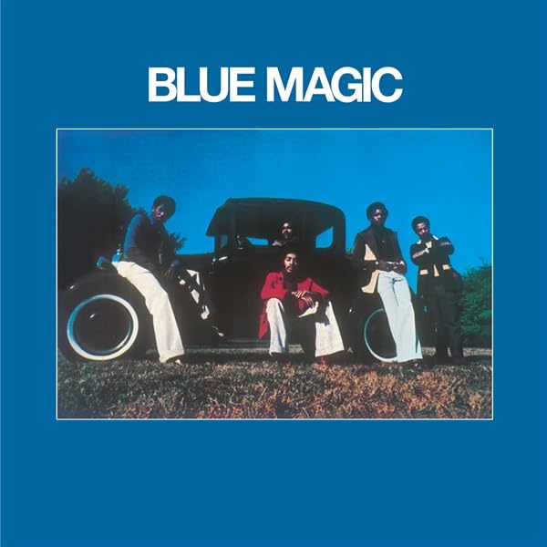 Album cover: group of men with a vintage car, blue background.