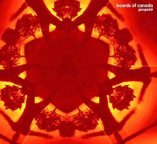 Kaleidoscopic view of trees against a bright orange and yellow sun-like background.