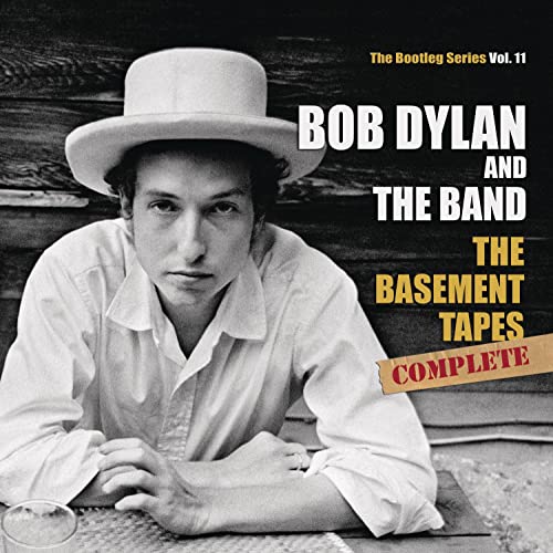 Black and white photo of Bob Dylan wearing a hat, with album text overlay.