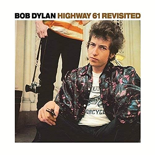 Bob Dylan album cover: a young man with a guitar and camera.