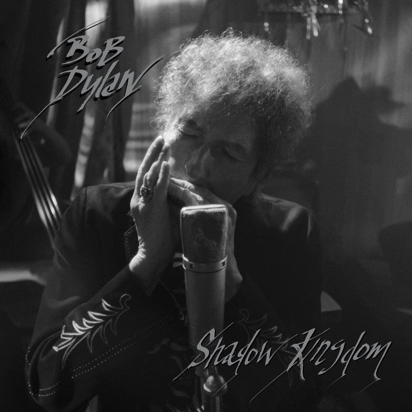 Black and white image of Bob Dylan singing into a microphone.