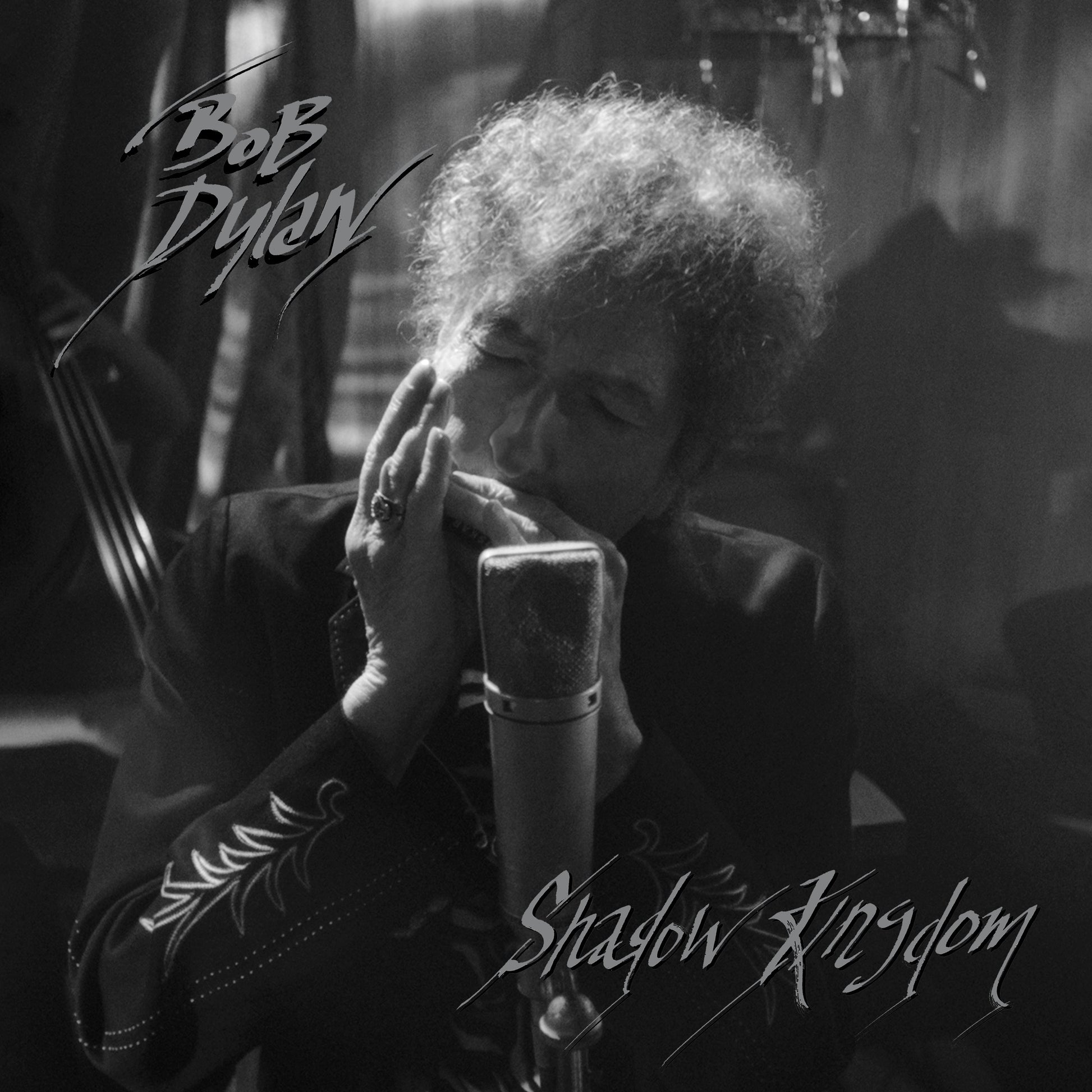 Black and white image of Bob Dylan singing into a microphone.