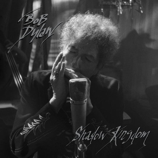 Black and white image of Bob Dylan singing into a microphone.