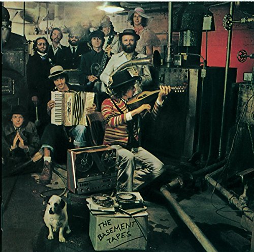 Bob Dylan and The Band in a basement with instruments, a dog, and equipment.