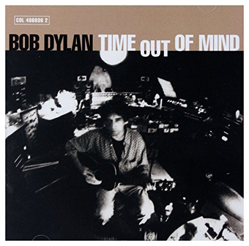 Bob Dylan playing acoustic guitar in a dimly lit recording studio on CD cover art.