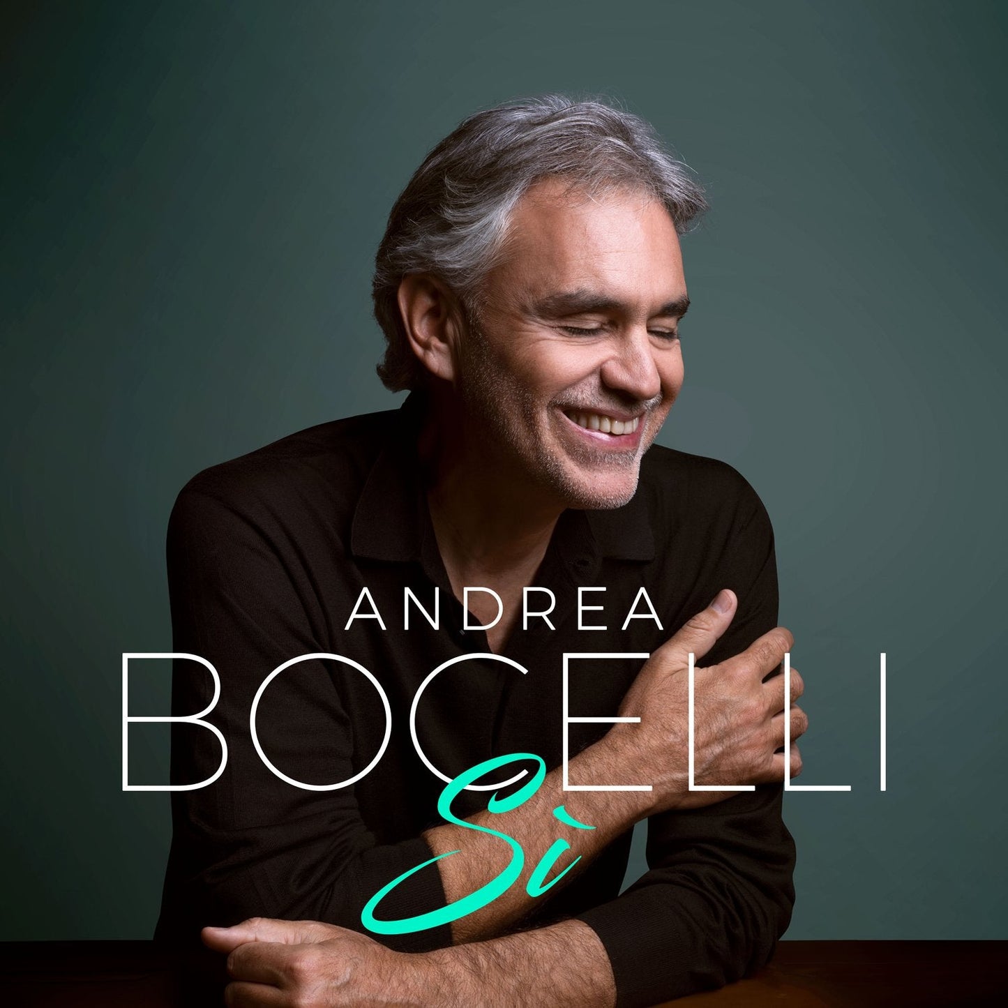 Andrea Bocelli album cover featuring a smiling man with gray hair against a dark background.
