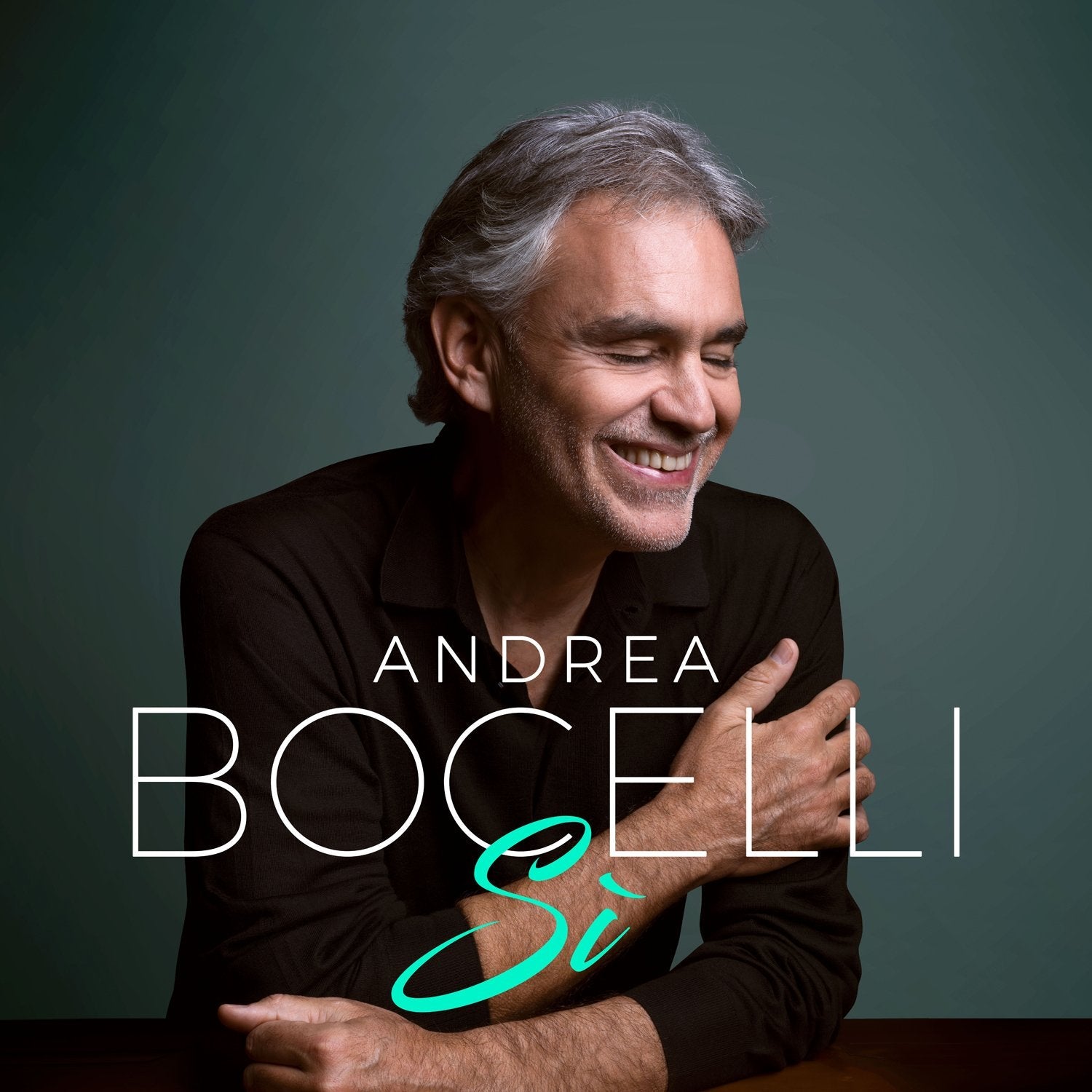 Andrea Bocelli album cover featuring a smiling man with gray hair against a dark background.